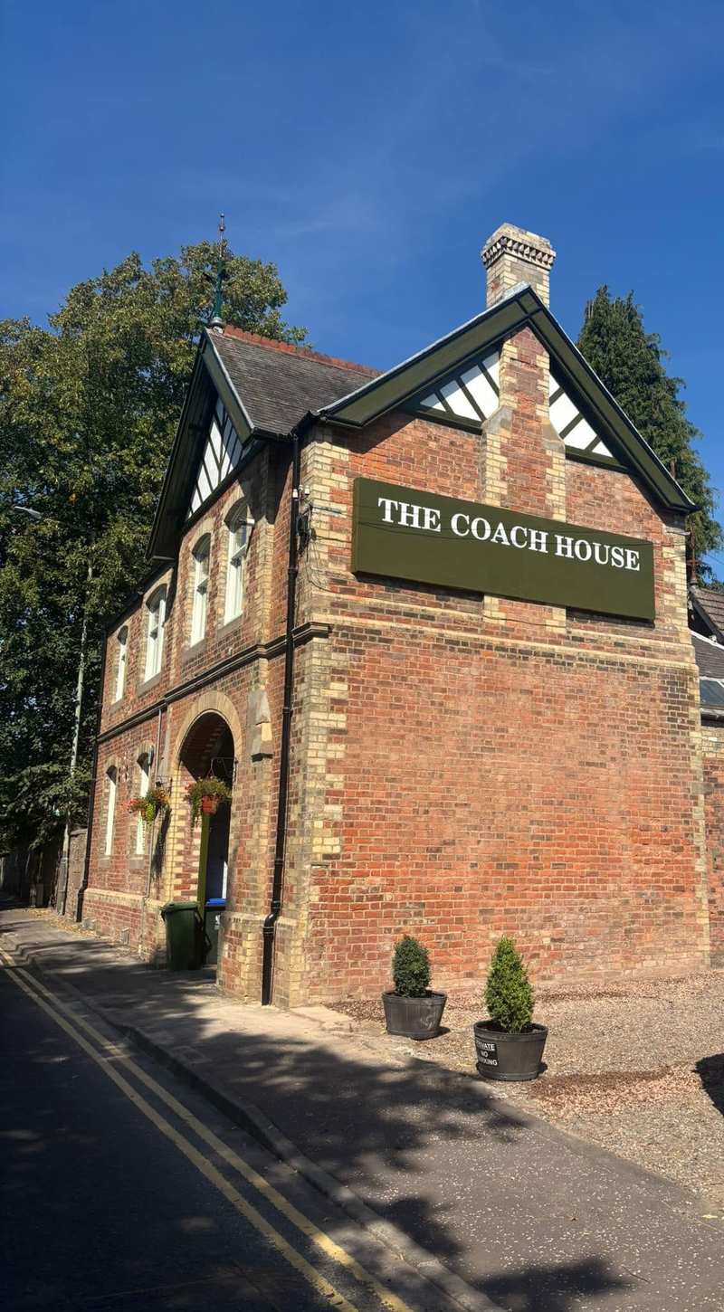 The Coach House in Perth, a red brick building with a timber gable, new name sign and brick chimney