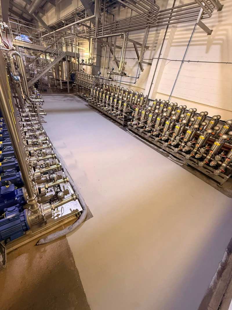Cream resin floor laid around the base of a stainless steel valve manifold
