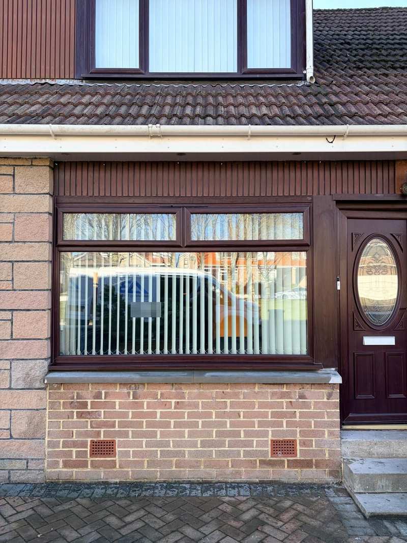 New grey window cill under a wide ground floor window, above a red brick panel with air vents
